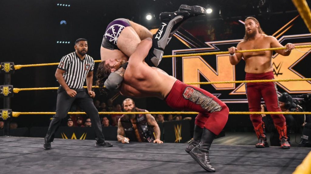 Steve Cutler suplexes Ivar while Wesley Blake watches