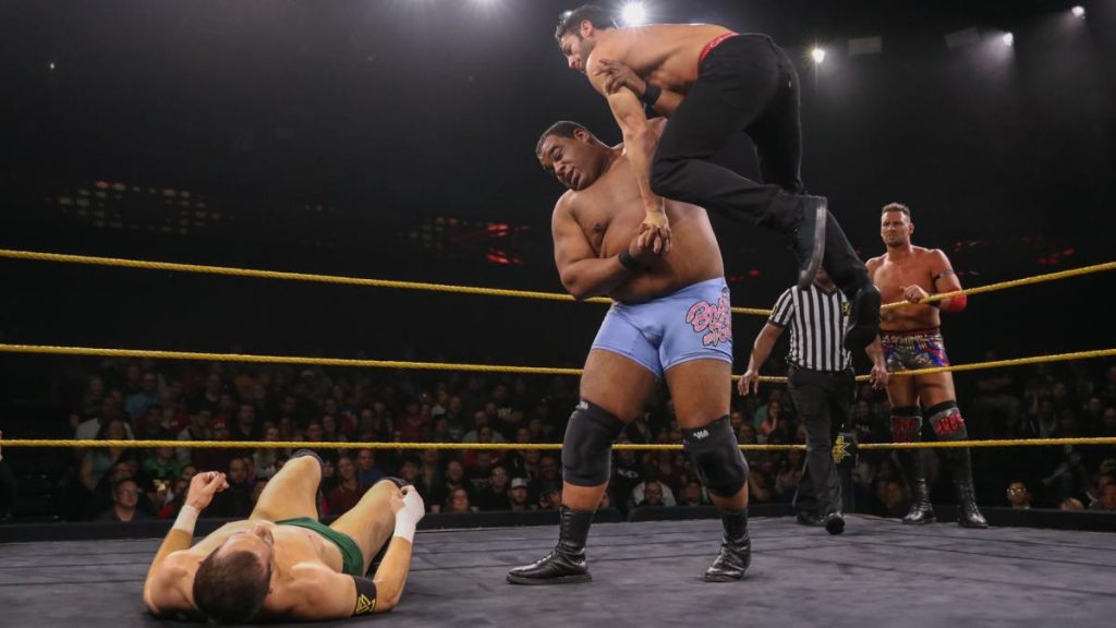 Keith Lee with Roderick Strong in the air. Kyle O'Reilly on the mat. Dominik Dijakovic in the background