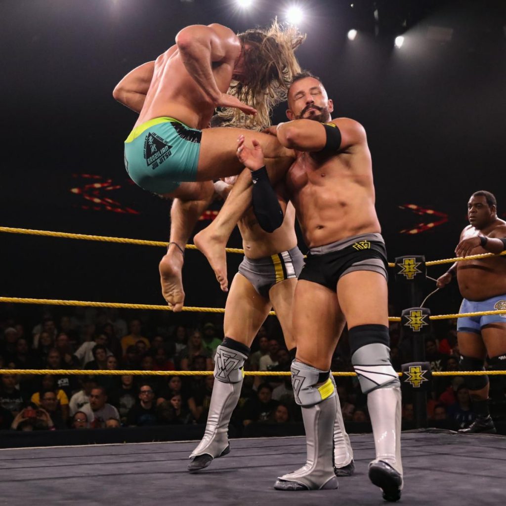 Matt Riddle knees Bobby Fish and Kyle O'Reilly, with Keith Lee watching on