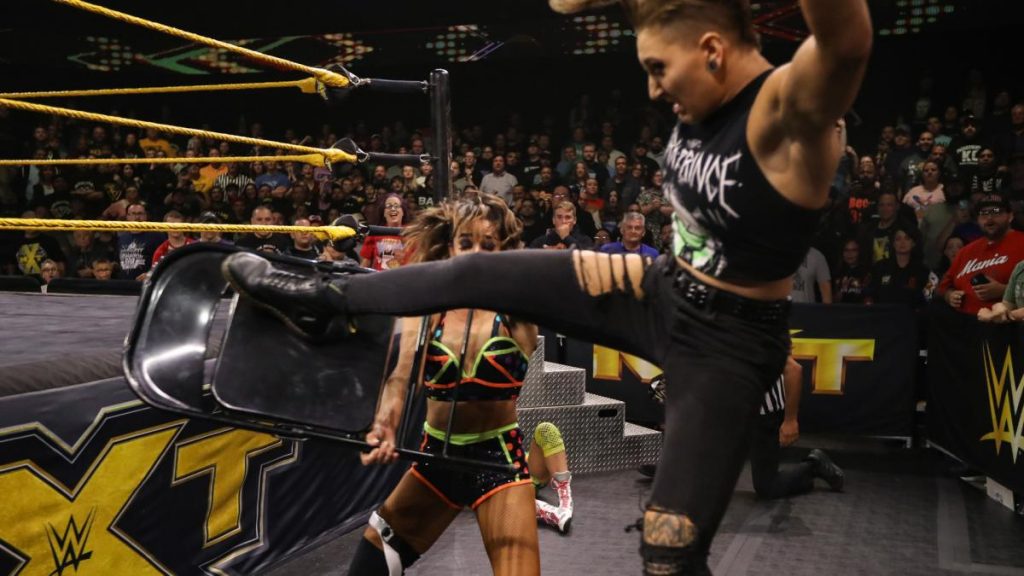 Rhea Ripley kicks a chair out of Dakota Kai's hands