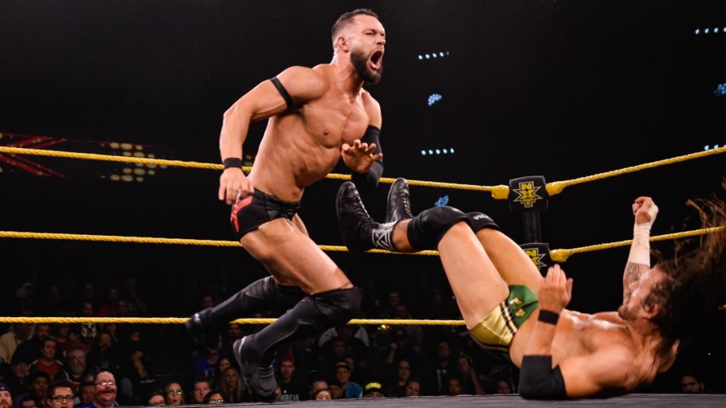 Finn Balor and Adam Cole mid-match