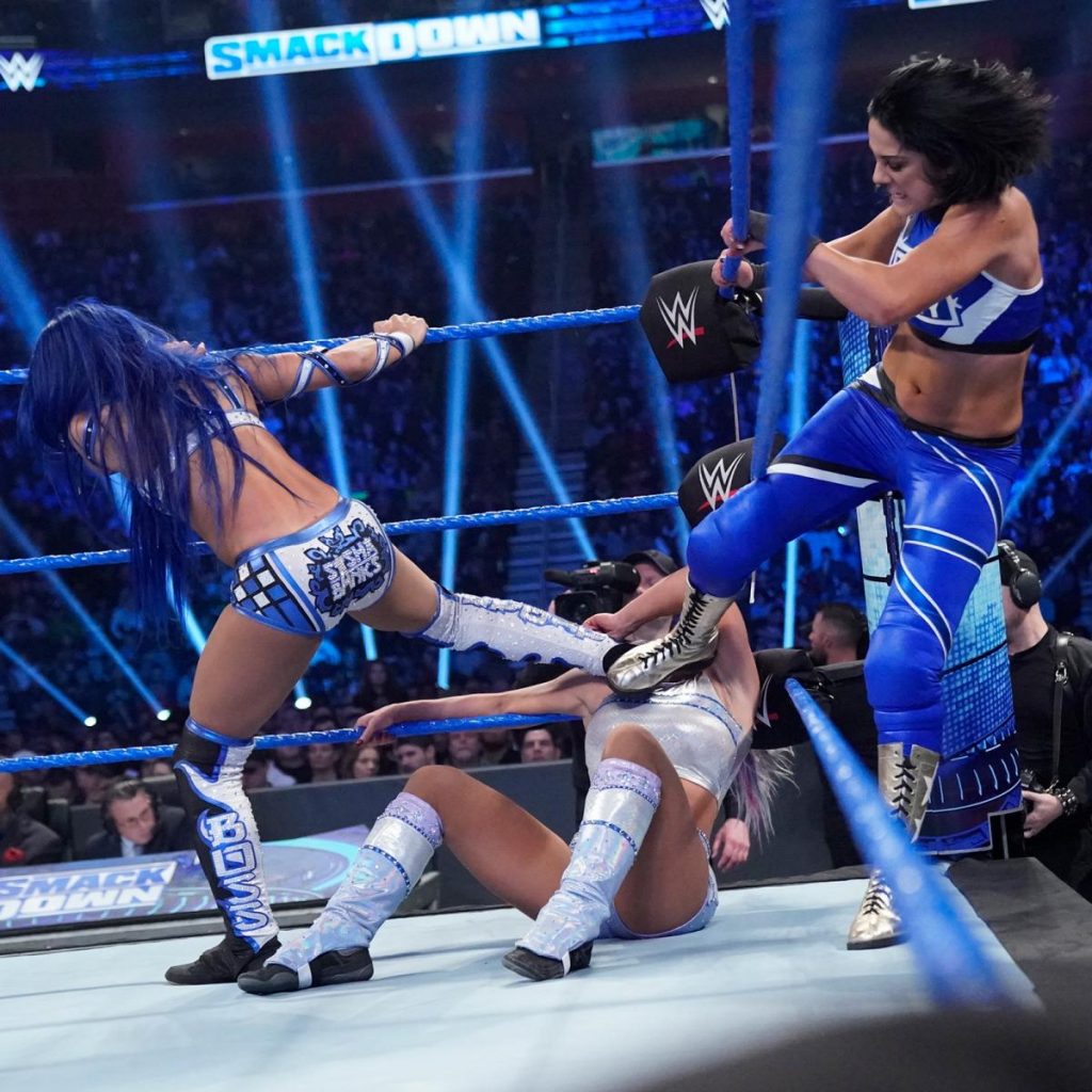 Bayley and Sasha Banks stomp on Dana Brooke in the corner