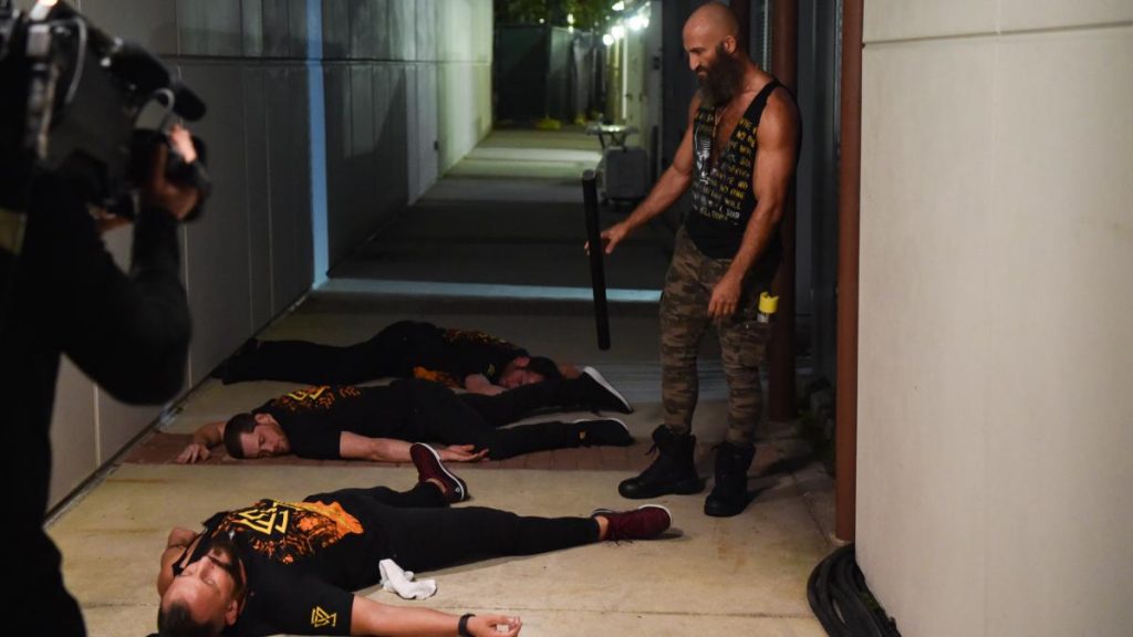 Tommaso Ciampa looks at the unconscious Bobby Fish, Kyle O'Reilly, ad Roderick Strong