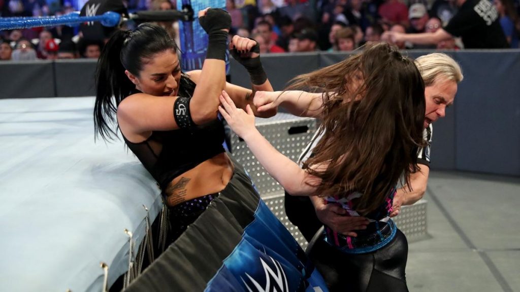 Nikki Cross with Sonya Deville in the ring skirt