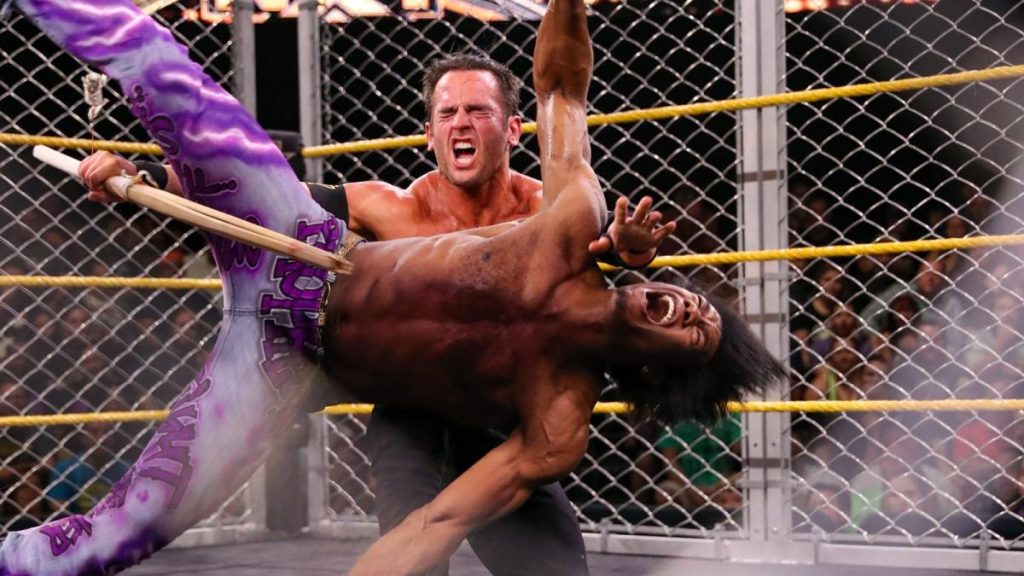 Roderick Strong gives Velveteen Dream a kendo stick assisted backbreaker in the cage