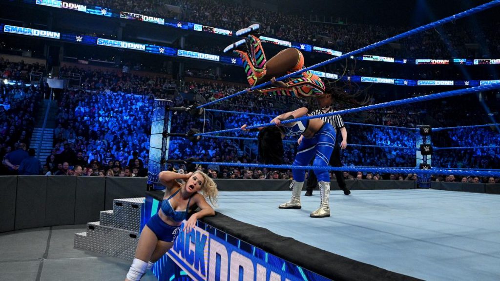 Naomi mid sunset flip on Bayley with Lacey Evans ringside