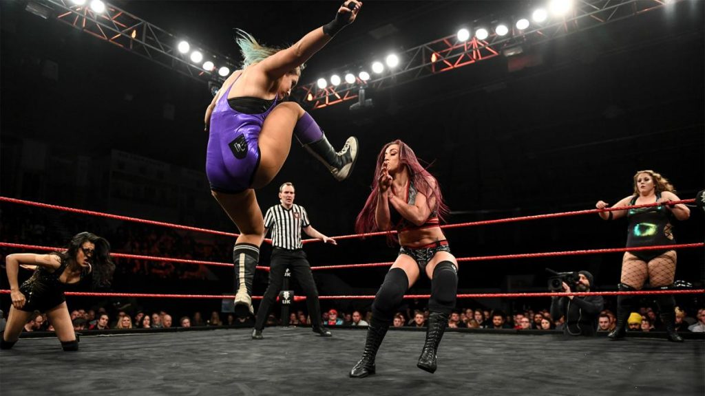 Dani Luna dropkicks Kay Lee Ray with Piper Niven and Jinny in the background