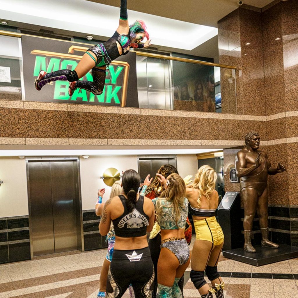 Asuka jumps off a balcony onto her Money in the Bank competitors