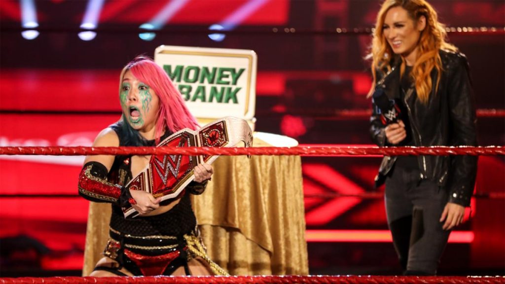 Asuka reacts to becoming champion with Becky Lynch in the background