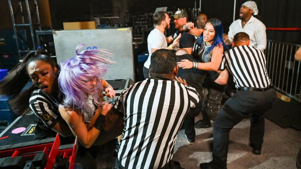 Johnny Gargano and Isaiah 'Swerve' Scott argue while officials try to separate Mia Yim and Candice LeRae