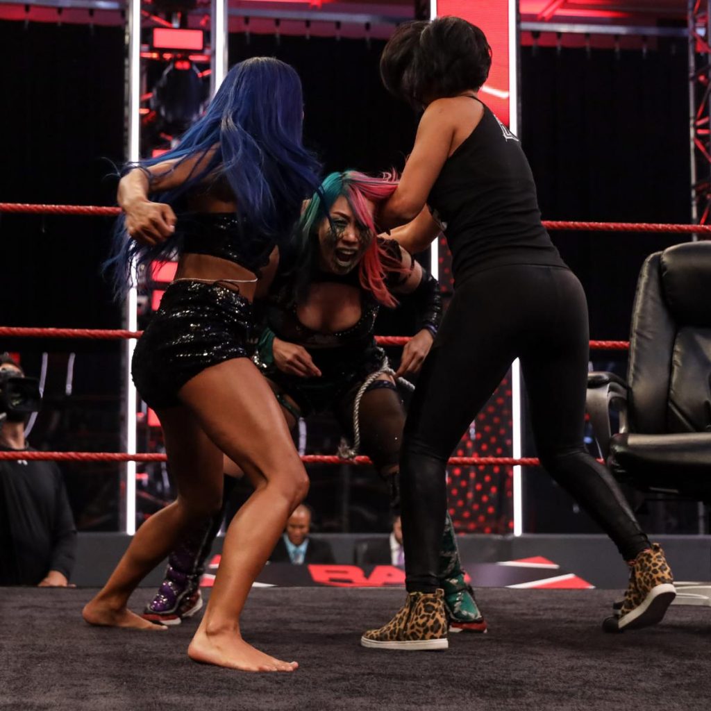 Sasha Banks and Bayley try to beat up Asuka. 
