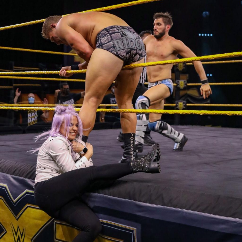 Candice LeRae grabs Ridge Holland's leg to give Johnny Gargano an advantage