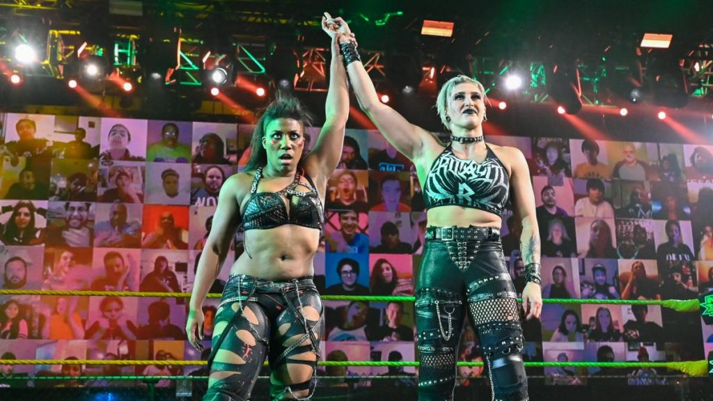 Ember Moon and Rhea Ripley celebrate beating Dakota Kai and Raquel Gonzalez