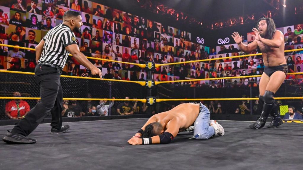 Cameron Grimes backs away from the ref who was zombie ref last week and away from Kushida in the process