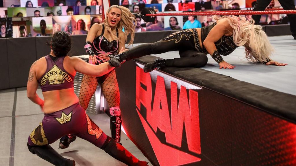 Shayna Baszler takes a baseball slide from Dana Brooke while Lana watches