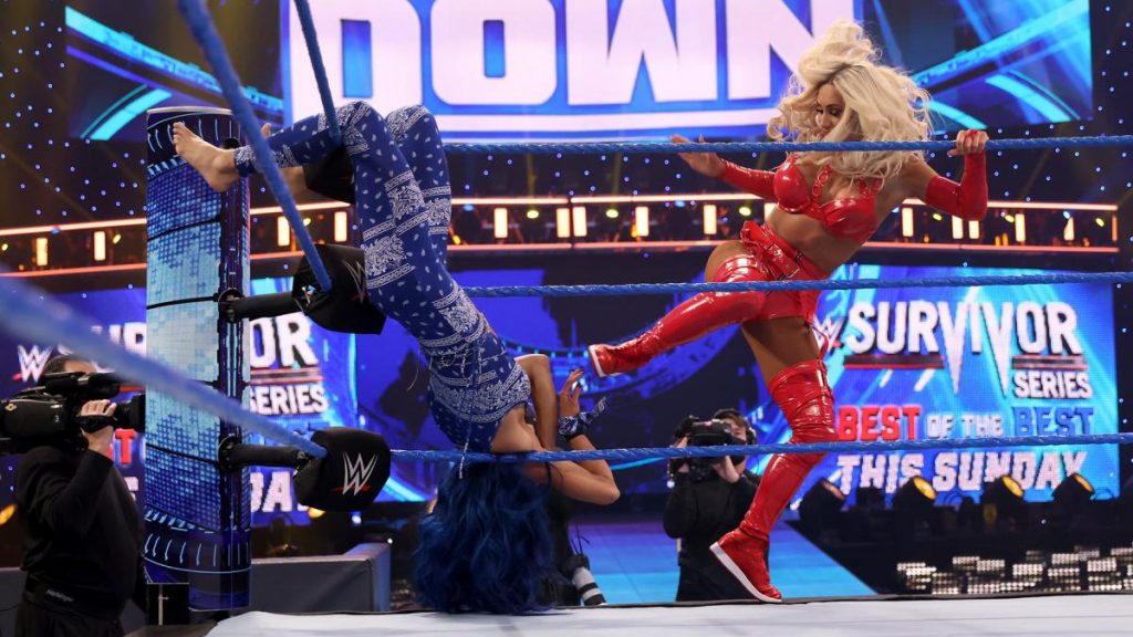 Carmella kicks a hung upside down Sasha Banks in the face