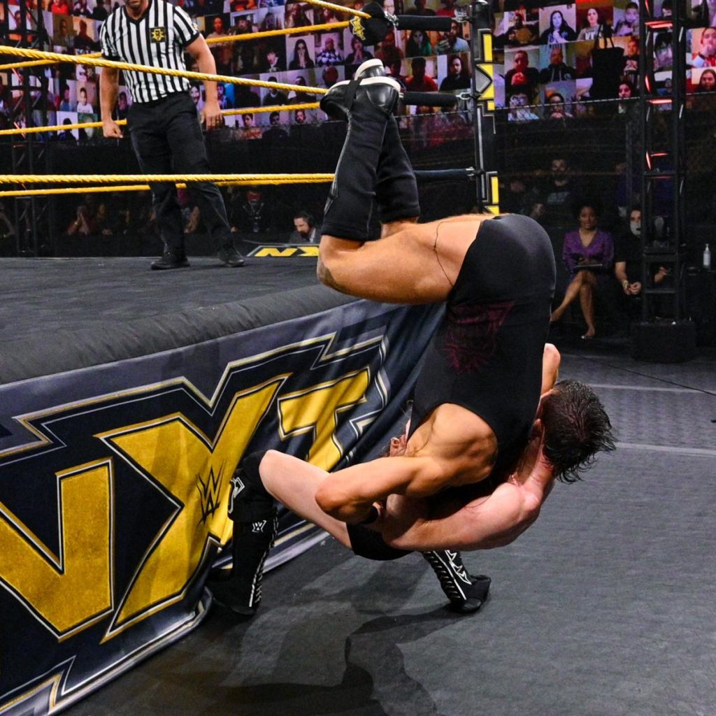 Kyle O'Reilly suplexes Pete Dunne off the apron