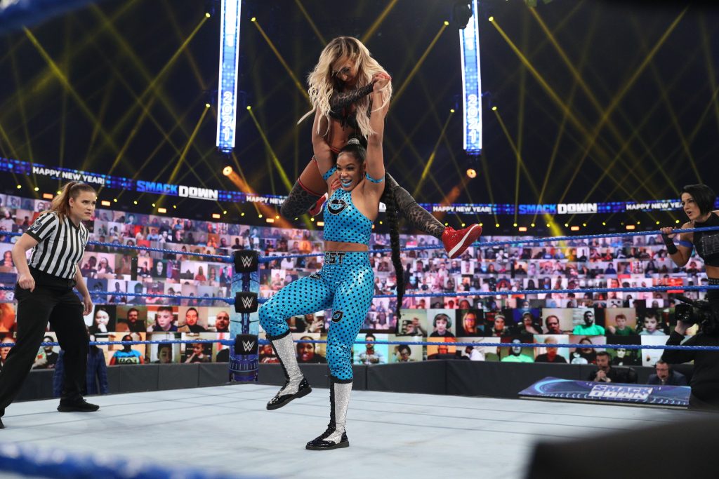 Bianca Belair with Carmella over her head