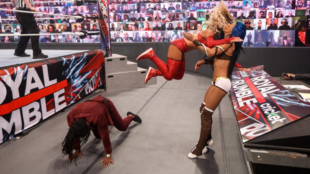 Carmella dives onto Sasha Banks after using Reginald as a springboard