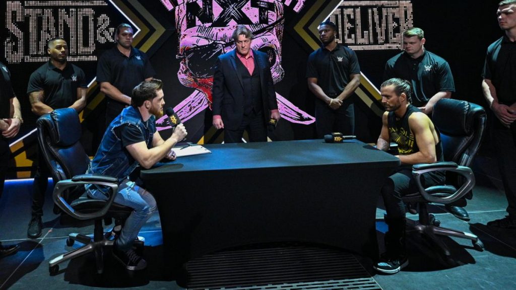 Kyle O'Reilly, William Regal, Adam Cole and security attend the contract signing