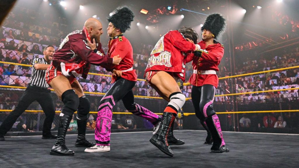 Breezango, dressed as Queen's Guard from the waist up, scrap with Grizzled Young Veterans