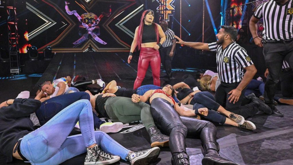 Io Shirai stands over the fallen locker room