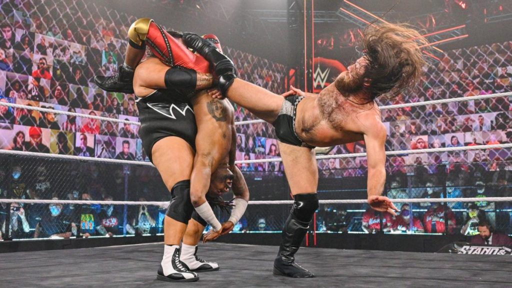 Cameron Grimes kicks Bronson Reed in the face while Reed holds Swerve upside down