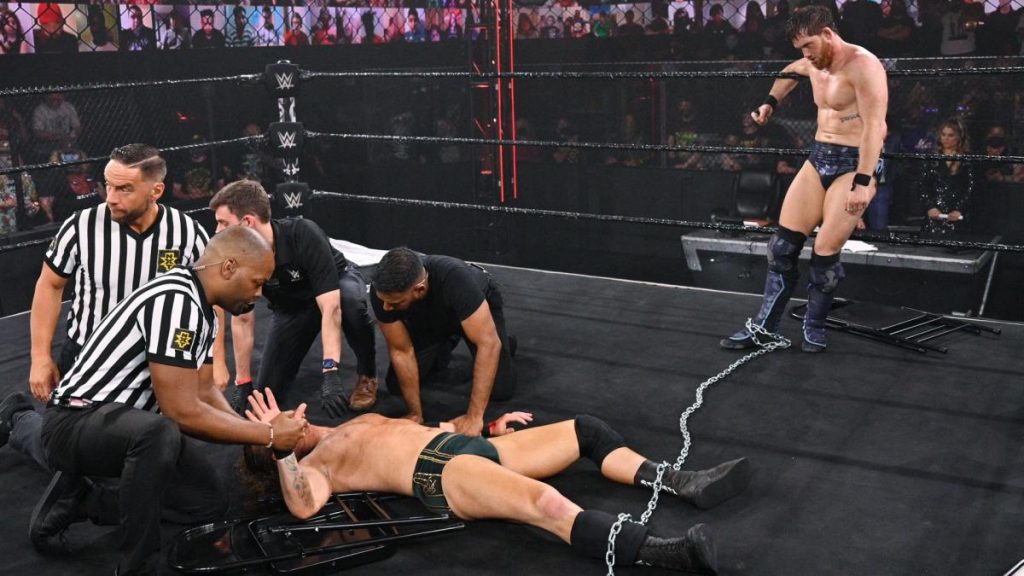 Kyle O'Reilly watches medics tend to Adam Cole