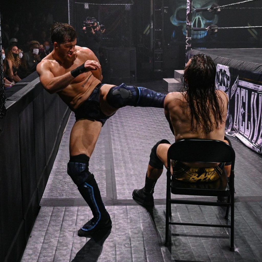 Kyle O'Reilly kicks a seated Adam Cole