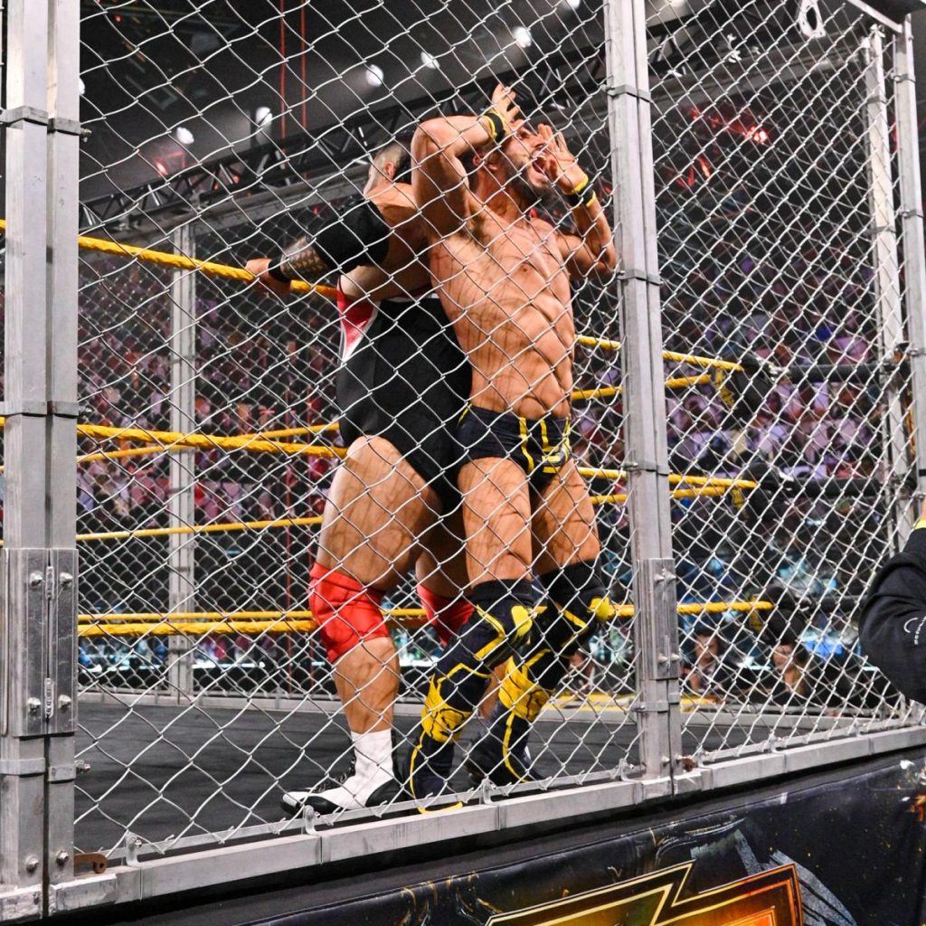 Bronson Reed squishes Johnny Gargano against the cell