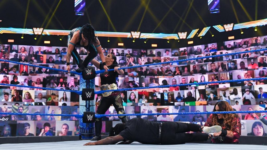 Shayna Baszler pushes Tamina off the turnbuckle while Nia Jax pulls Reginald from the ring