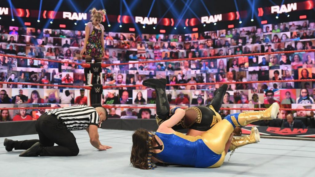 Nikki Cross fights Shayna Baszler with Alexa Bliss stood on a corner