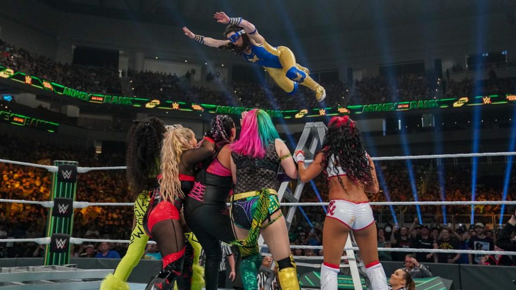 Nikki A.S.H. flies from a ladder onto Naomi, Natalya, Tamina, Asuka, and Zelina Vega