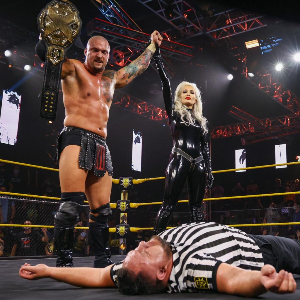 Karrion Kross and Scarlett stand over Samoa Joe