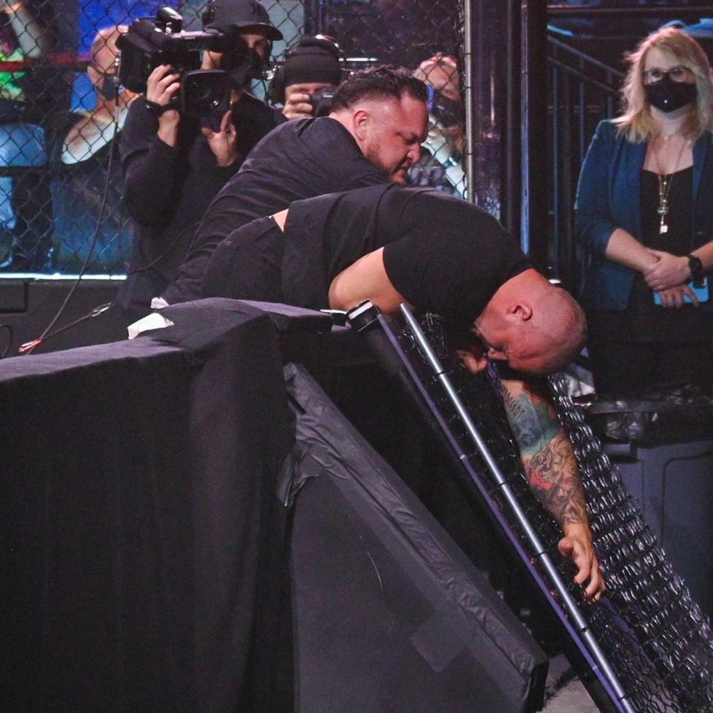 Samoa Joe knocks a plexiglass barrier over with Karrion Kross' head.