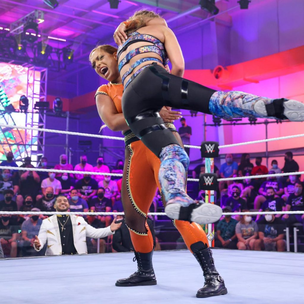 Elektra Lopez lifts Anna Scheer for a slam