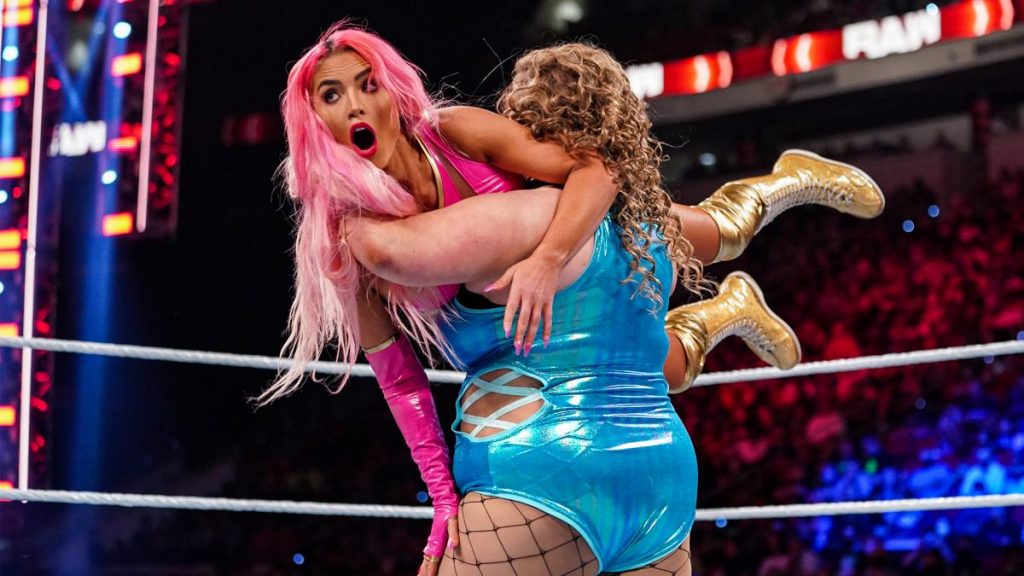 Doudrop with Eva Marie in her arms for a slam