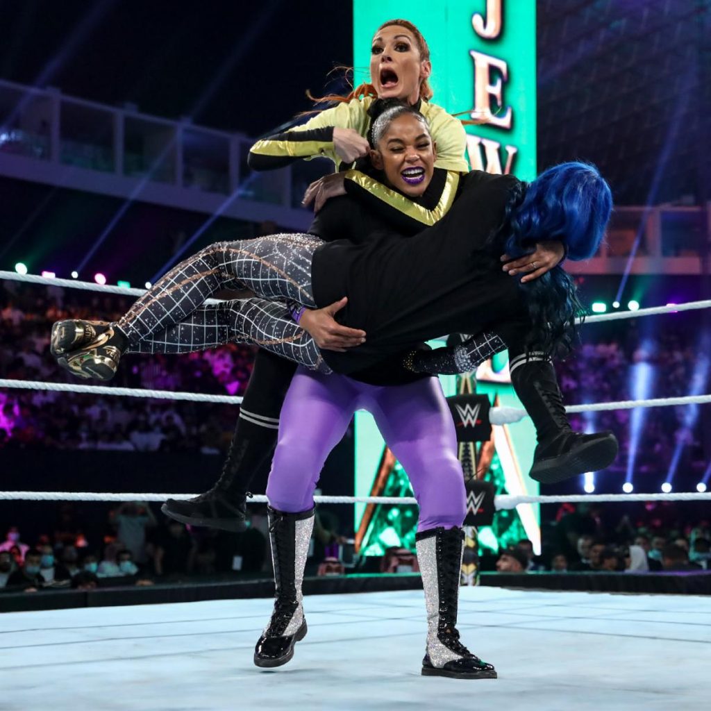 Bianca Belair holding Sasha Banks, with Becky Lynch on her back at Crown Jewel