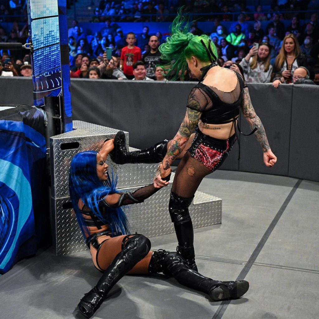 Shotzi kicks Sasha Banks' arm while it's trapped in the steps.