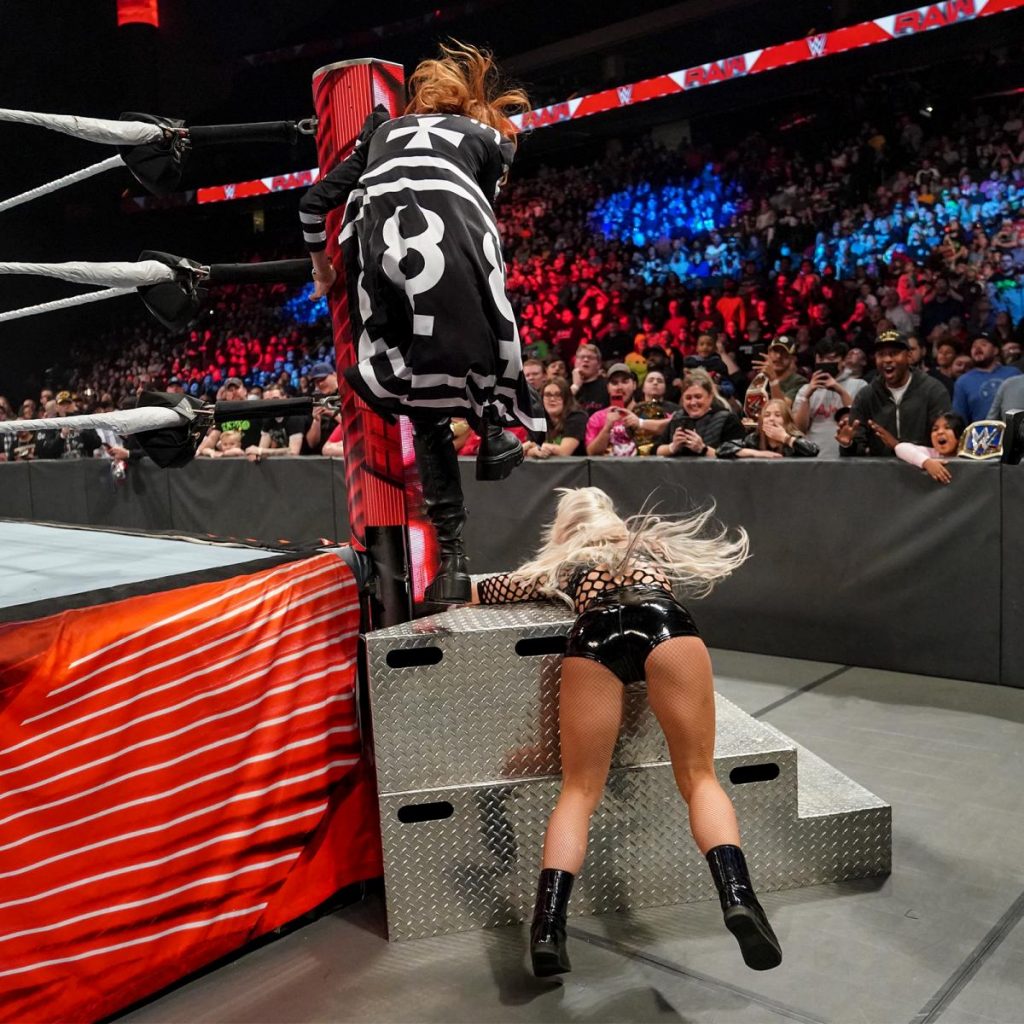 Becky Lynch stamps on Liv Morgan's trapped in the steps arm.