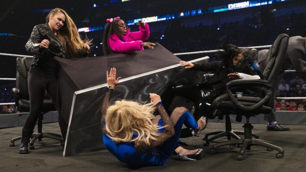 Ronda Rousey and Naomi tip the signing table onto Charlotte Flair and Sonya Deville