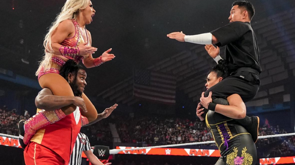 Dana Brooke on Reggie's shoulders looks across at Akira Tozawa on Tamina's shoulders