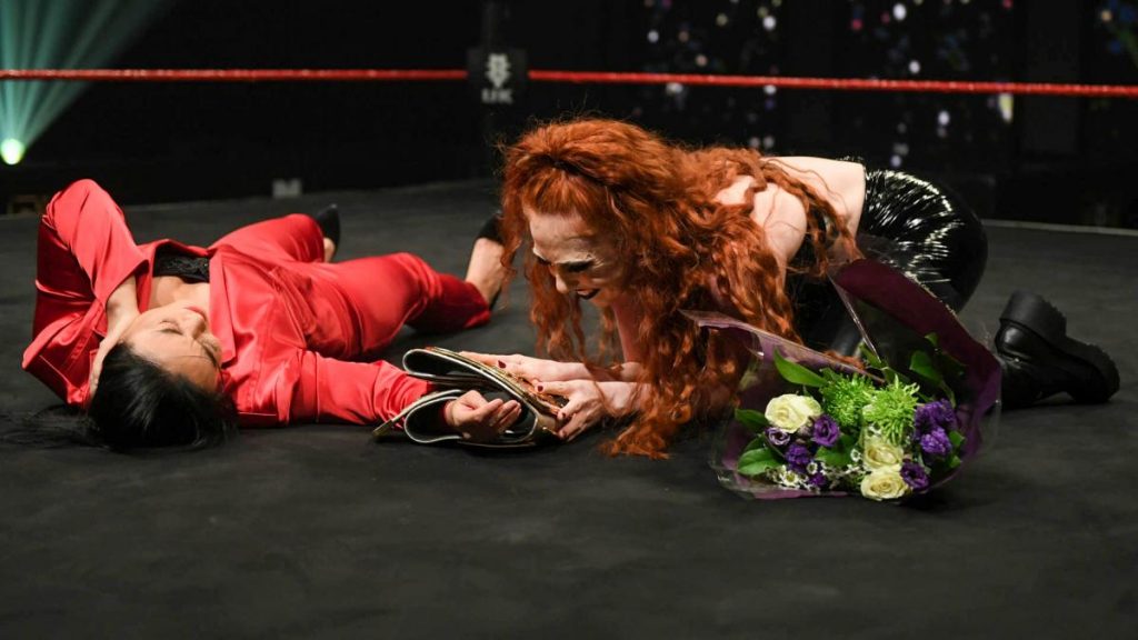 Isla Dawn looks at the NXT UK Women's Championship after knocking Meiko Satomura out and before stealing her flowers.